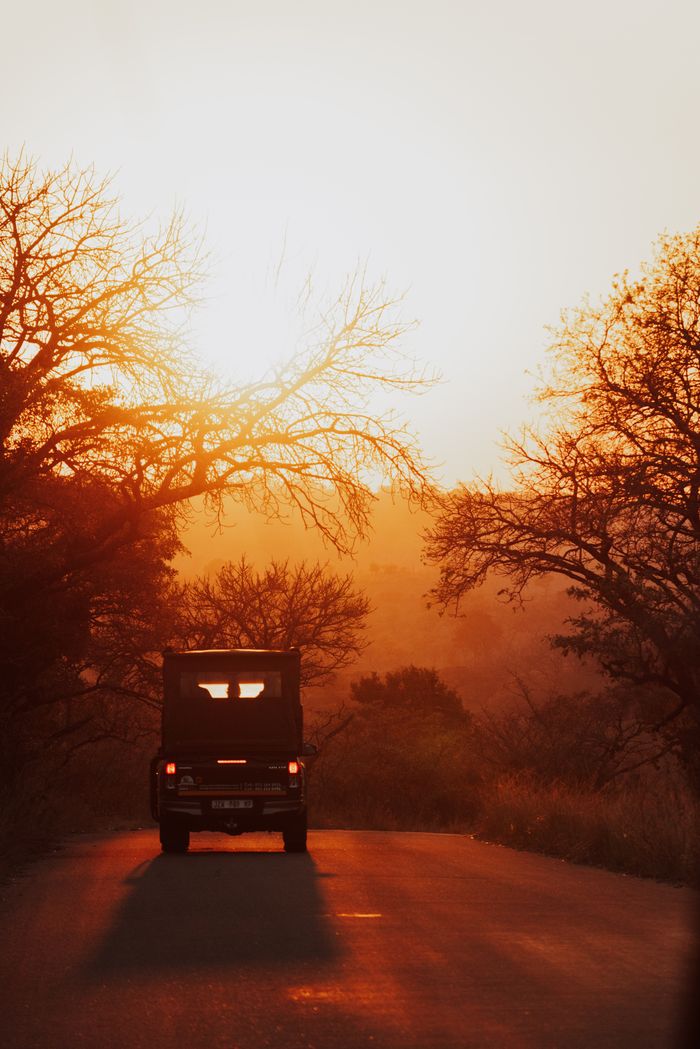 A safari vehicle against a scenic South African sunset, capturing the essence of adventure.